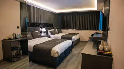 a hotel room with two beds and a desk at Cip Hotel & Spa - İstanbul Bakırköy City Center in Istanbul