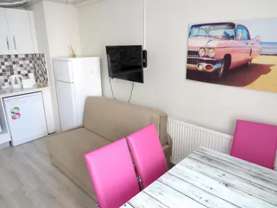 a dining room with a table and a pink car on the wall at Istanberry - Paradise Two Bedroom Apartments in Istanbul