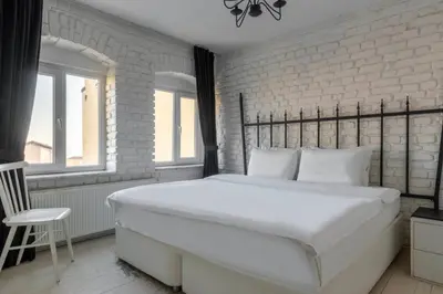 a large white bed in a room with a brick wall at 5 Apartment Galata in Istanbul