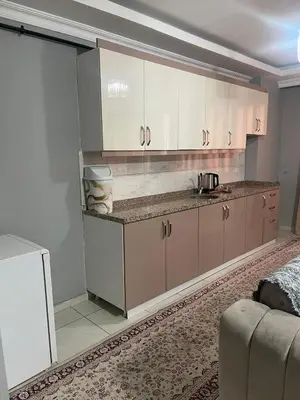 a kitchen with white cabinets and a counter top at Rosse Hotel in Esenyurt