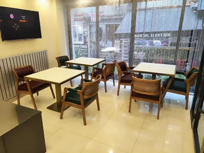 a restaurant with tables and chairs and a window at Hotel Esve Istanbul in Istanbul