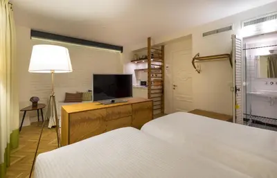 a bedroom with two beds and a flat screen tv at Pera Neuf in Istanbul