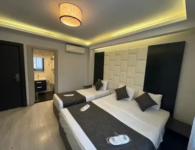 a hotel room with two beds and a bathroom at Aram Edessa Hotel in Istanbul