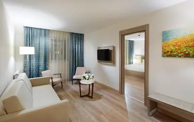a living room with a couch and a bedroom at Rox Hotel Istanbul in Istanbul