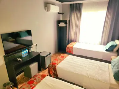 a hotel room with two beds and a flat screen tv at City Park Suites City Center Corlu in Corlu