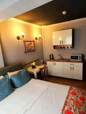 a bedroom with a bed and a small kitchen at City Park Suites City Center Corlu in Corlu
