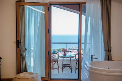 a bathroom with a tub and a view of the ocean at VillaQua Boutique Hotel in Sile