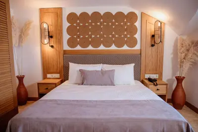 a bedroom with a large white bed with wooden walls at VillaQua Boutique Hotel in Sile