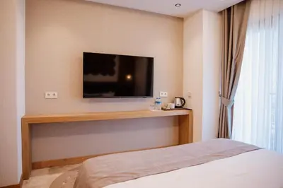 a bedroom with a tv on the wall and a bed at VillaQua Boutique Hotel in Sile