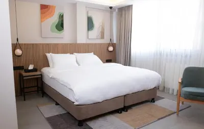 a bedroom with a large bed and a blue chair at BeL LETTO HOTEL in Istanbul