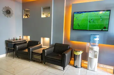 a waiting room with two chairs and a tv on the wall at Rio's Hotel AİRPORT in Istanbul