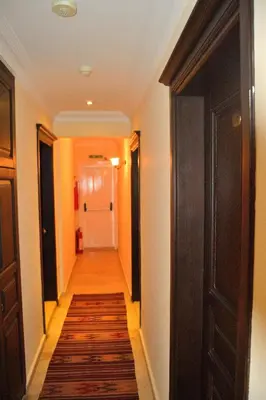 a hallway with a long hallway with a door and a rug at Hotel Alp Guesthouse in Istanbul