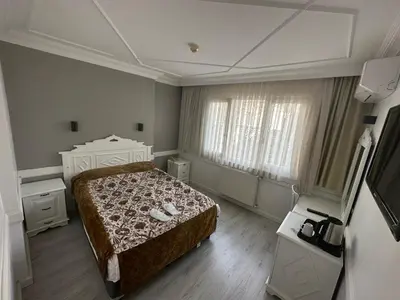 a bedroom with a bed and a dresser and window at Hotel Alp Guesthouse in Istanbul