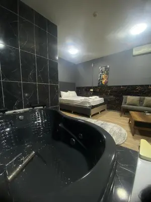 a bathroom with a black bath tub and a living room at Rena Apart Hotel in Istanbul
