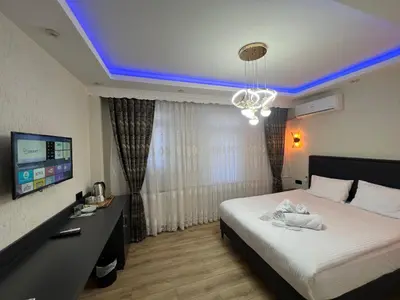 a hotel room with a bed and a tv at Feycem Suites Hotel in Istanbul