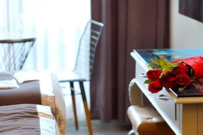 a room with a table with a bouquet of roses on it at Parmada Hotel in Istanbul