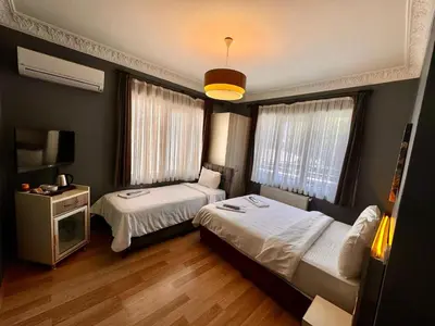 a hotel room with two beds and a television at Armoni City Otel Kadıköy in Istanbul