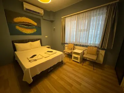 a bedroom with a bed and a table and chairs at Armoni City Otel Kadıköy in Istanbul