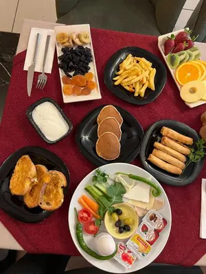 a table with plates of food on a red table at SULTAN SÜLEYMAN APART HOTEL in Istanbul