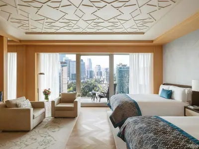a bedroom with two beds and a large window at Raffles Istanbul in Istanbul