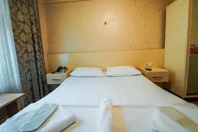 a bedroom with a bed with two white towels on it at SAHRA OTEL in Istanbul