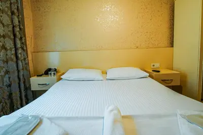 a bedroom with a large white bed with two pillows at SAHRA OTEL in Istanbul