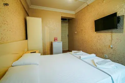 a bedroom with a bed and a tv on the wall at SAHRA OTEL in Istanbul