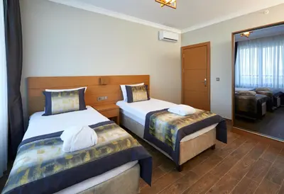 a hotel room with two beds and a mirror at Hattusa Vacation Business Thermal Hotel Saray in Saray