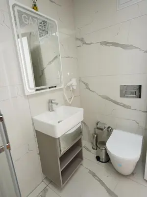 a white bathroom with a sink and a toilet at gazelle suites in Istanbul