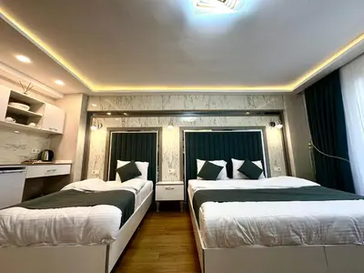 two beds in a room with two windows at gazelle suites in Istanbul