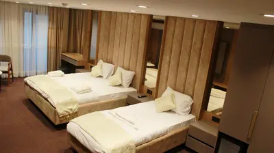 a hotel room with two beds and a mirror at Sabiha Sultan Hotel-Karakoy in Istanbul