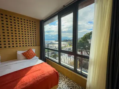 a bedroom with a bed and a large window at Mihman Hotel in Tuzla