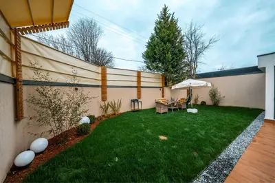 a backyard with a fence and a table and an umbrella at Luxon Sapanca Family Villas in Sakarya