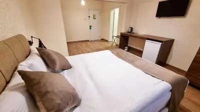 a bedroom with a white bed and a television at La Pearl Konaklama in Istanbul