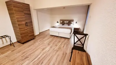 a bedroom with a white bed and a wooden floor at La Pearl Konaklama in Istanbul