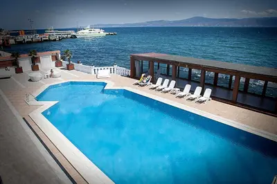 a large swimming pool with a boat in the water at Montania Special Class Hotel in Mudanya