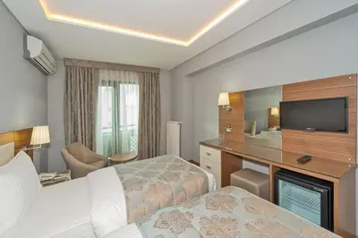 a hotel room with a bed and a flat screen tv at Floransa City Hotel in Istanbul