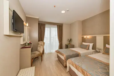 a hotel room with two beds and a television at Marcello Hotel in Istanbul