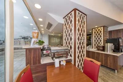 a restaurant with a table and chairs and a kitchen at Marcello Hotel in Istanbul