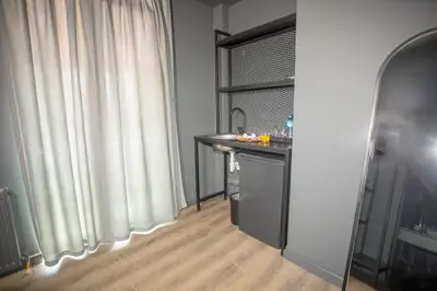 a bathroom with a sink and a window with white curtains at Arkem Deluxe in Istanbul