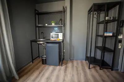 a room with a desk with a microwave and shelves at Arkem Deluxe in Istanbul