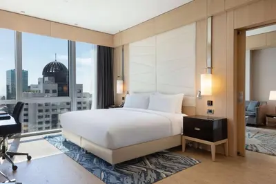 a bedroom with a large white bed and a desk at Wyndham Grand Istanbul Levent Hotel & Conference Center in Istanbul