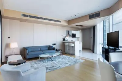 a living room with a blue couch and a tv at Wyndham Grand Istanbul Levent Hotel & Conference Center in Istanbul