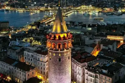 a tall building with a clock tower at night at Central of İstanbul near to so many historic place in Istanbul