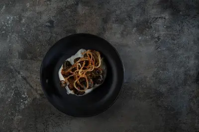 a black plate of food with spaghetti on a table at Régie Ottoman Istanbul - Special Category in Istanbul