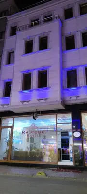 a store front of a white building with blue lights at Raimond Hotel in Istanbul