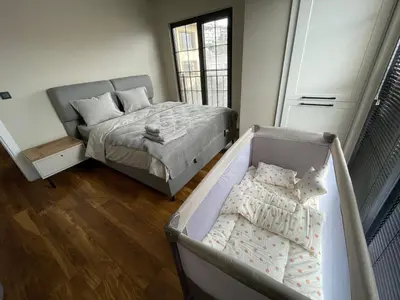 a bedroom with a crib and a bed with pillows at ARC HOUSE in Istanbul