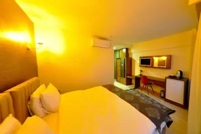 a hotel room with a bed with a yellow wall at Atlantik Butik Hotel in Tekirdag