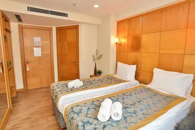 two beds in a hotel room with towels on them at Cumbali Plaza Hotel in Istanbul