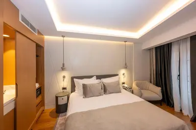 a bedroom with a large white bed and a chair at Baver Hotel in Istanbul